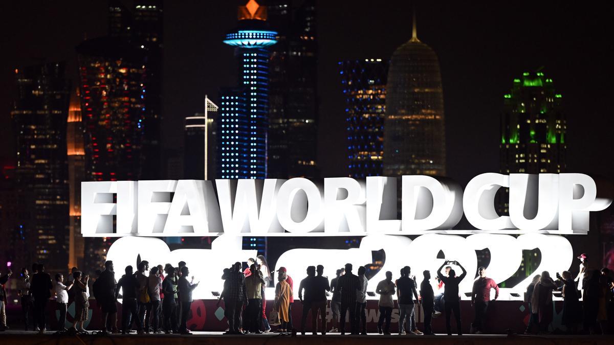 Turistas y aficionados se hacen fotos frente al cartel &quot;Copa Mundial de la FIFA Qatar 2022&quot; en el Doha Corniche antes de la Copa Mundial de la FIFA Qatar 2022.