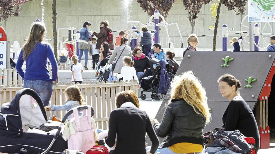 Varias madres con sus hijos en un parque.