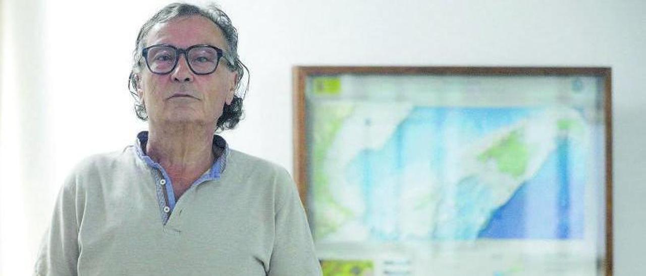 Antoni Garau posa junto a un mapa topobatimétrico del Mar Balear. |  MANU MIELNIEZUK