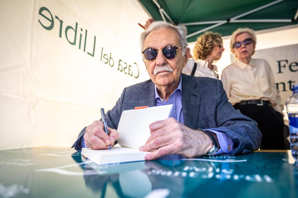 El escritor Eduardo Mendoza firma un ejemplar de su libro 'La intriga del funeral inconveniente', durante el Sant Jordi 2026.