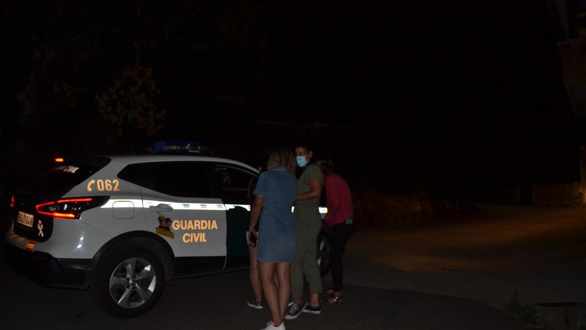 Un grupo de vecinos  de Vime ante un coche de la Guardia Civil