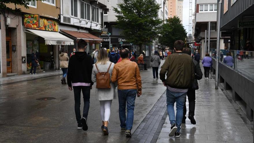 Varias personas pasean por una calle.