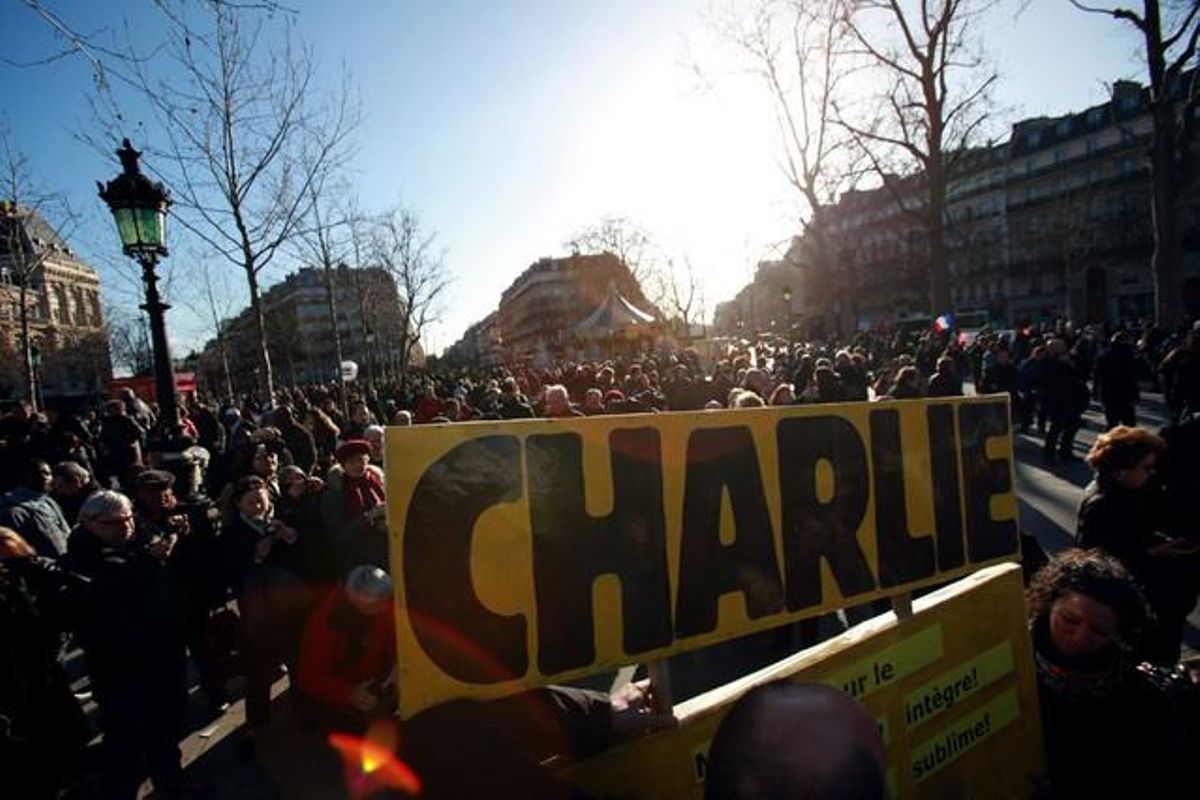 Centenars de persones al voltant d’una pancarta de ’Charlie’ en la manifestació contra el terrorisme de París.