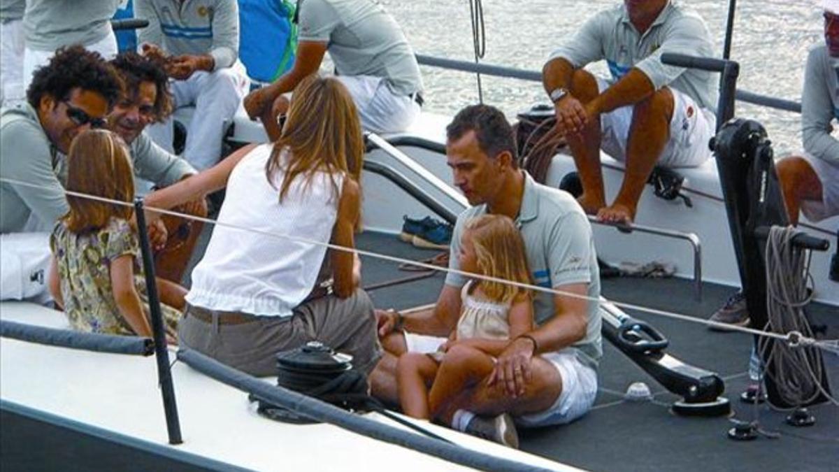 Felipe, con Letizia (de espaldas) y sus hijas, en un barco durante la Copa del Rey de vela, en agosto del 2010.