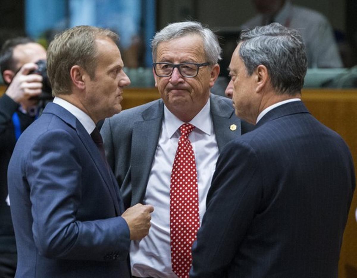 El president de la Comissió Europea, Jean-Claude Juncker (centre), parla amb el president del Consell Europeu, Donald Tusk (esquerra), i el president del BCE, Mario Dragui, el 25 de juny a Brussel·les.