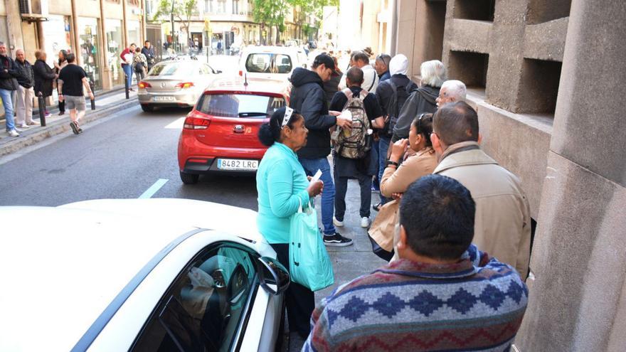 Varias personas hacen fila, ayer, en el comedor social El Carmen, en Zaragoza.  | JOSEMA MOLINA