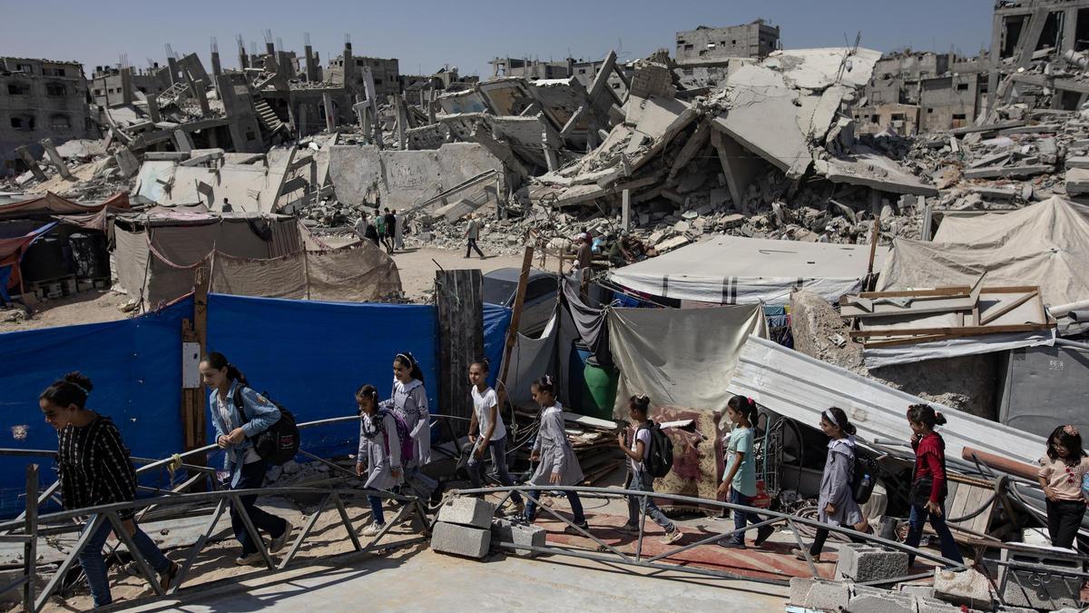 Niños palestinos pasan junto a edificios destruidos en Jan Yunis, en el sur de la Franja de Gaza.