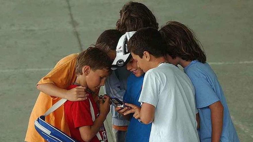 Un grupo de niños con un teléfono móvil.
