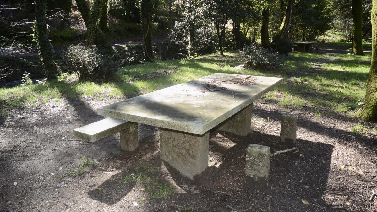 Una mesa con uno de los bancos en mal estado en el parque de Barosa, en Barro.