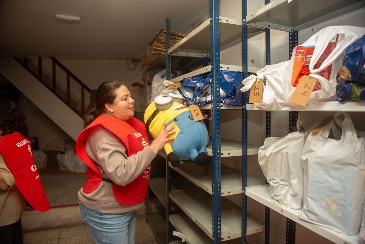Una voluntaria de Cáritas Interparroquial de A Coruña, trabajando en la campaña de Reyes de la entidad, esta semana, en el local de la calle Pan de Soraluce 2, en Os Mallos.