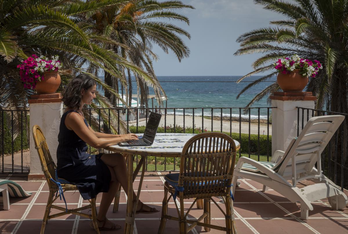 Una mujer teletrabaja desde la playa