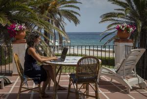 Una mujer teletrabaja desde la playa