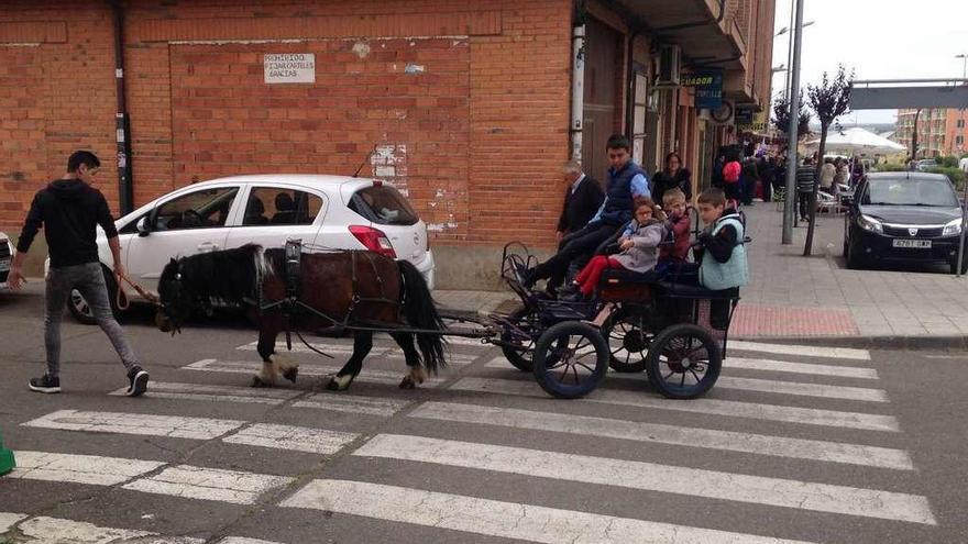 Un grupo de niños y niñas recorre una calle toresana en una calesa.