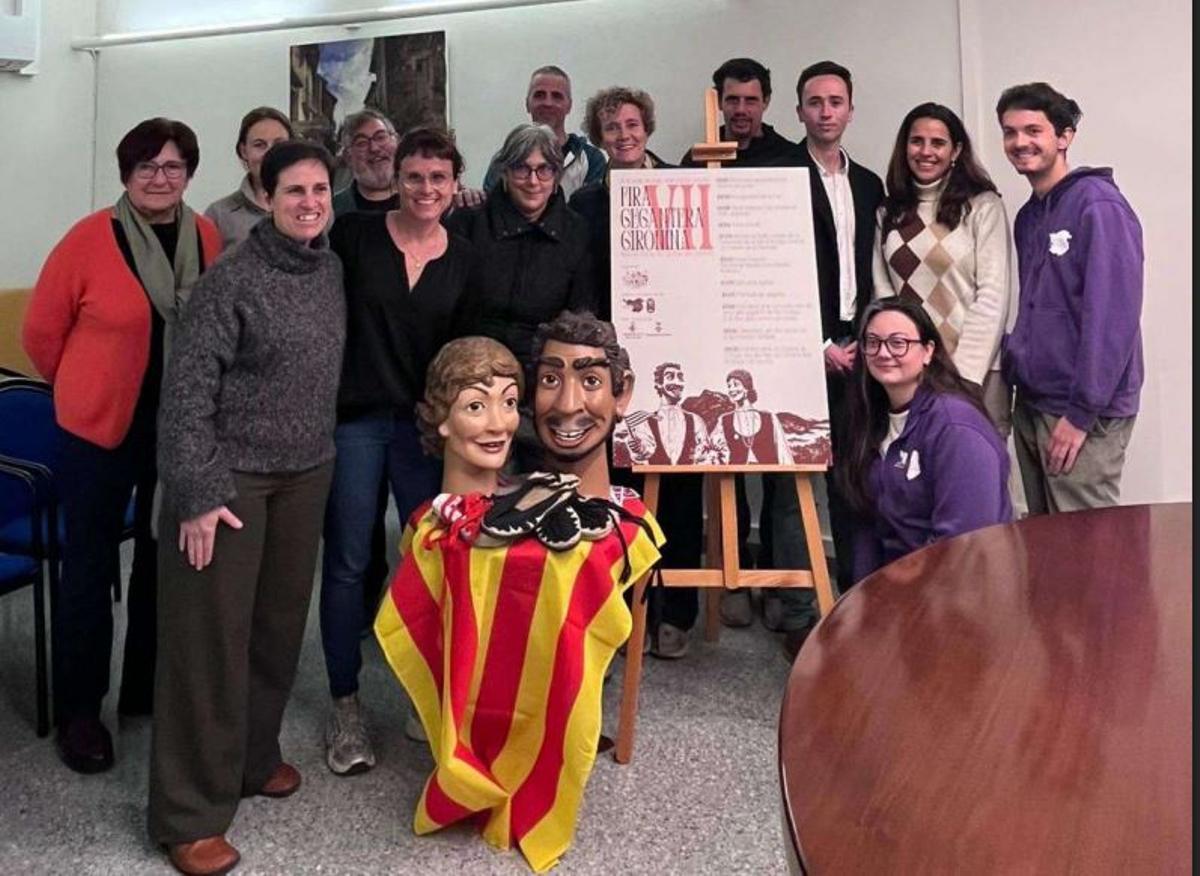 Foto de grup durant la presentació del cartell de la Fira Gegantera de les Comarques Gironines, amb els gegants al davant.