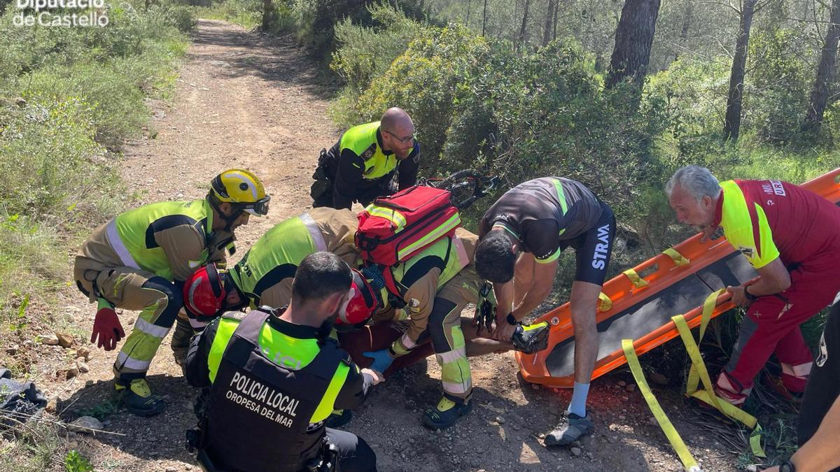 Bomberos y agentes de la Policía Local de Orpesa auxilian al ciclista accidentado en el lugar donde sufrió la caída.