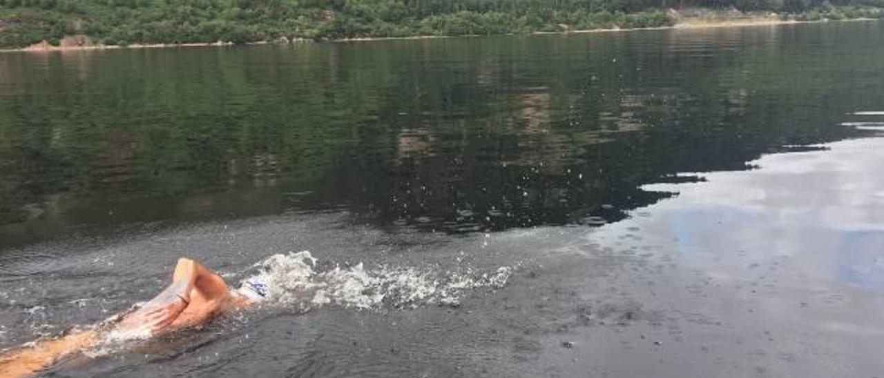 Los nadadores, con el patrón del barco, a los pies del lago.