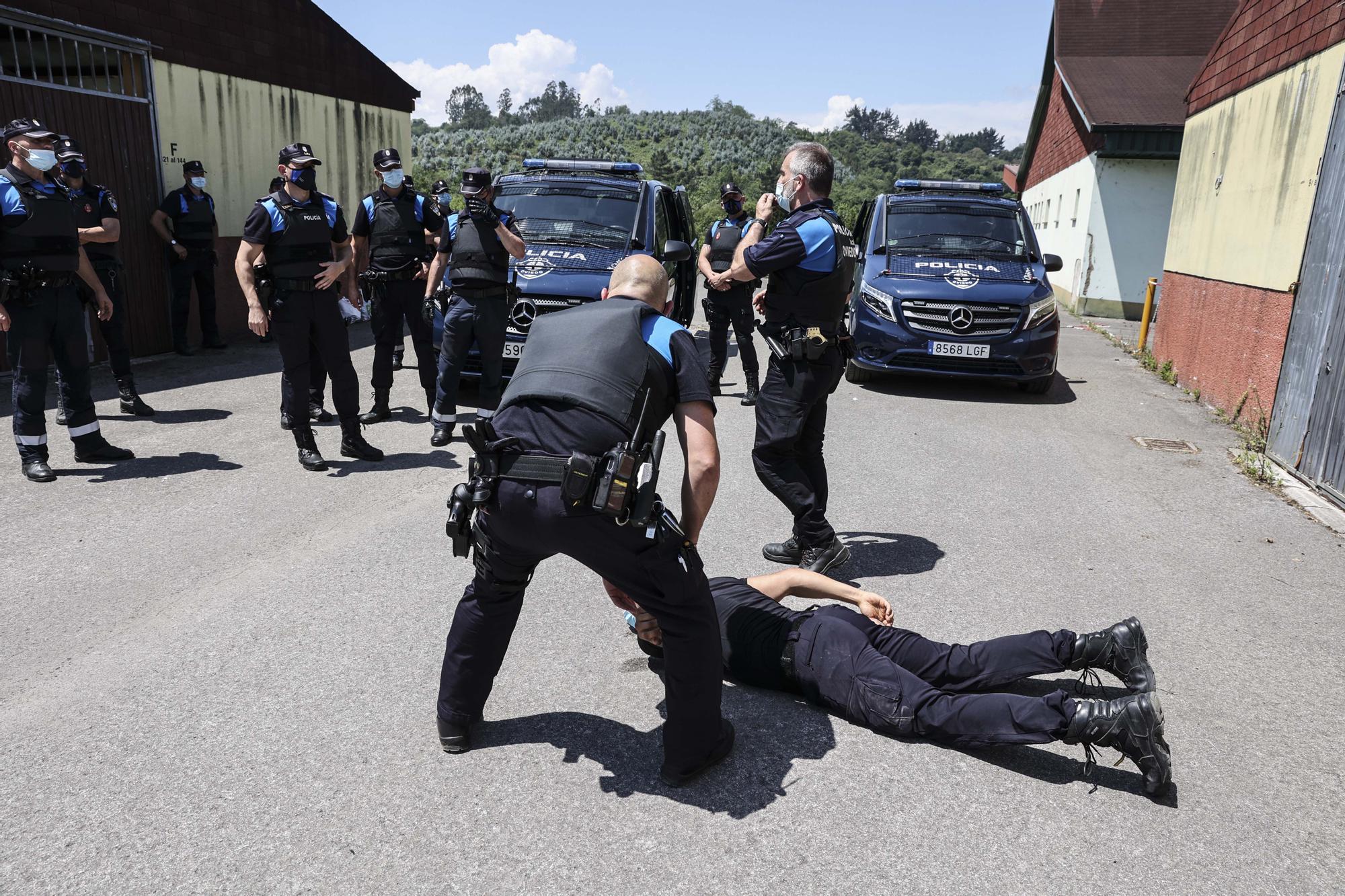 Agentes recreando una actuación para reducir a un delincuente.