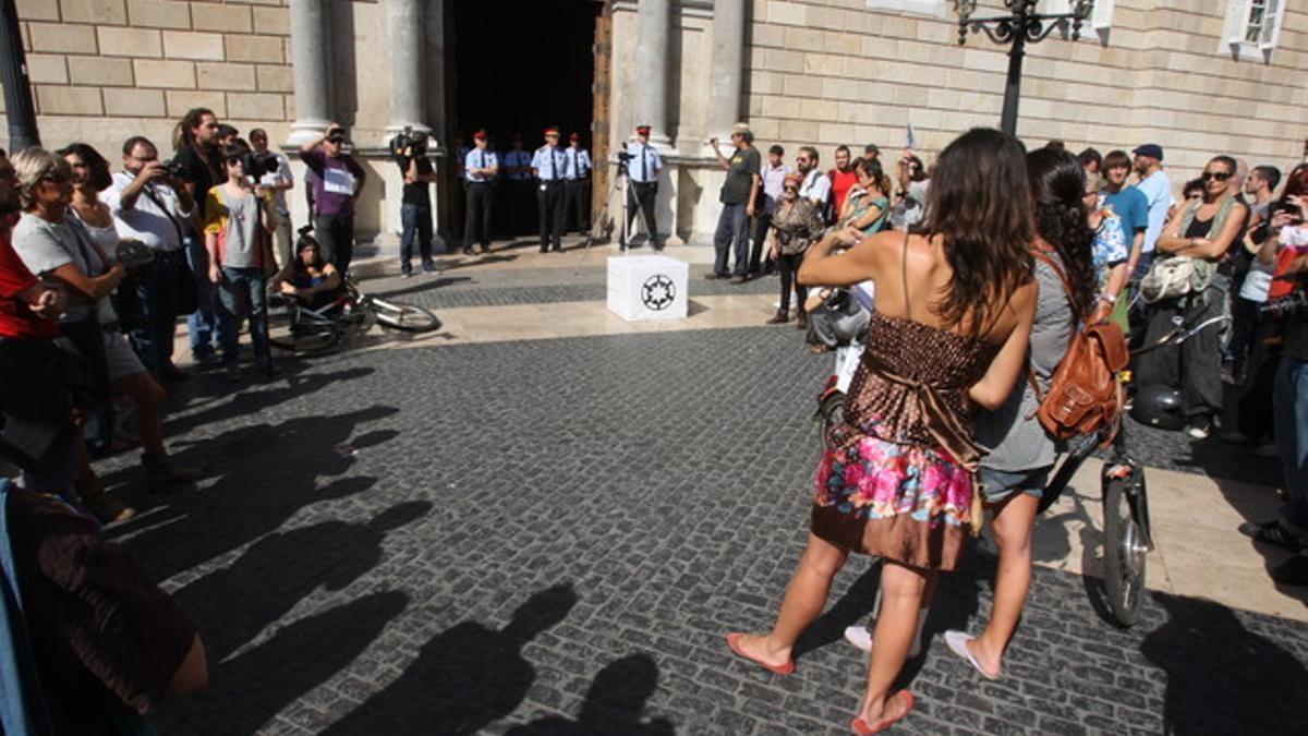 El grupo de indignados que ha presentado la querella contra Puig, ante la Generalitat, en la plaza de Sant Jaume de Barcelona.