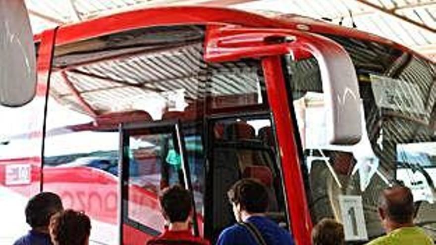 Varias personas se suben a un autobús con destino Madrid.