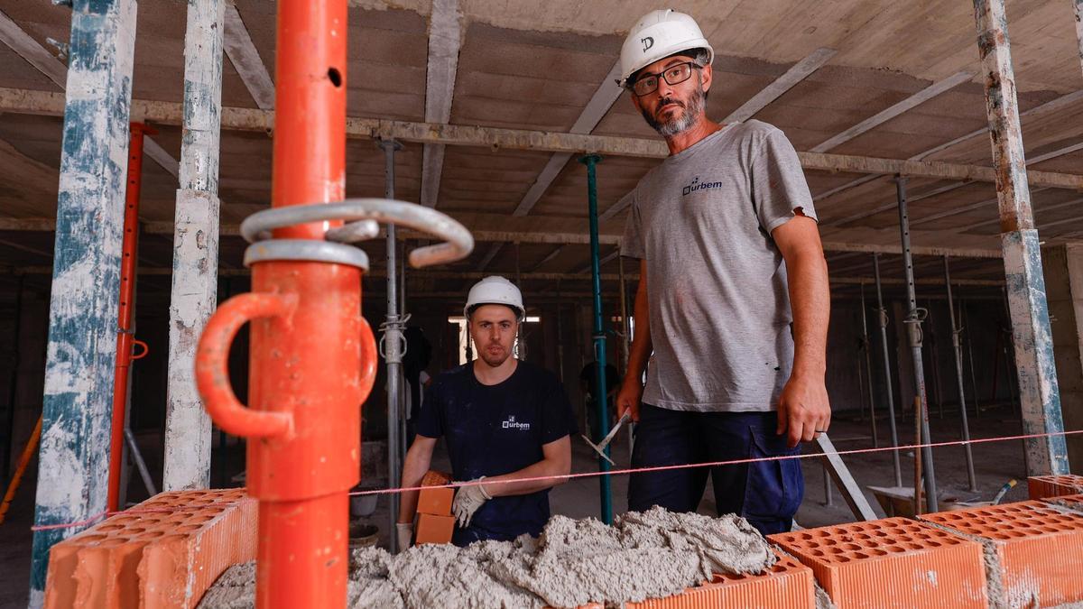 Los obreros Abraham Piñero y David Pretel, el jueves en un edificio en construcción en Paterna.