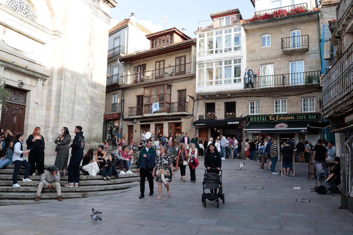 Turistas en la plaza de la Iglesia con el Jack Sparrow de La Colegiata vigiándolos desde el balcón