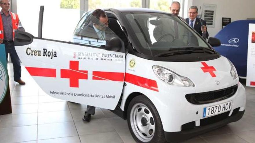 Los presidentes del Rotary y la Cruz Roja suben al pequeño vehículo.