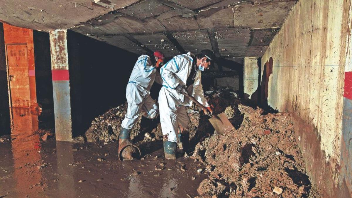 Operarios trabajan en la limpieza de un garaje privado en Picanya, ayer.