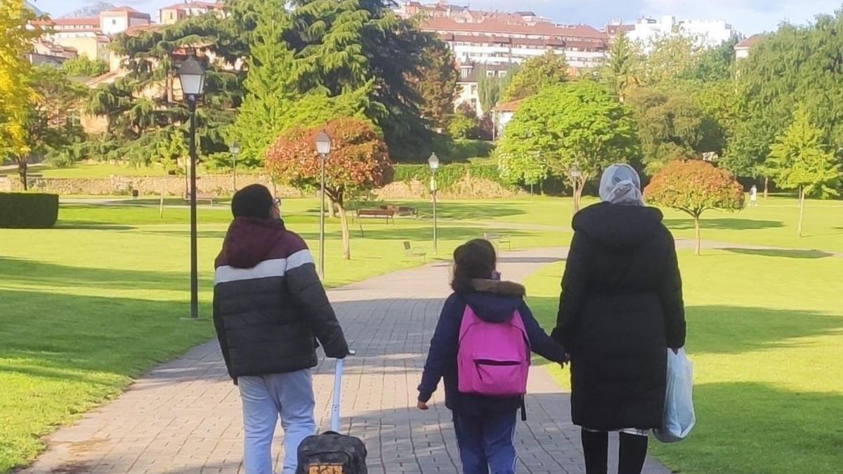 Una familia de inmigrantes pasea por un parque. | EL PERIÓDICO