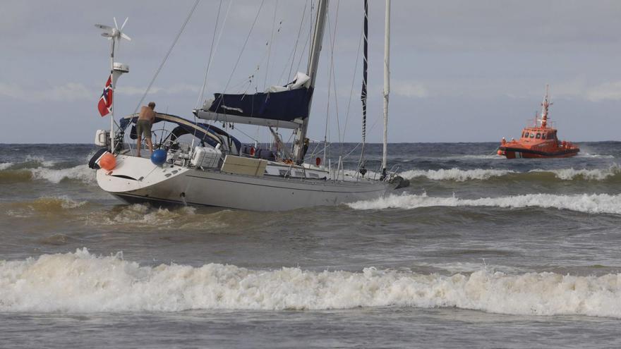 1. Un momento de la operación con la zódiac de Salvamento. 2. El velero varado.  3. Curiosos animando al dispositivo de auxilio a los tripulantes noruegos. 4. Uno de los socorristas que participaron en la maniobra desde el agua.  5. Panorámica de la zona donde encalló el barco. 6. El patrón de la embarcación, maniobrando durante la operación frustrada. 7. Vecinos siguiendo el operativo. | |  R. SOLÍS