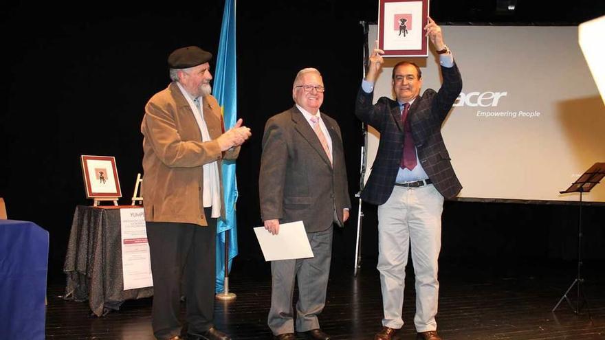 Isidro Caballero levanta su premio junto a Milio Rodríguez (izquierda) y Facundo Fernández.