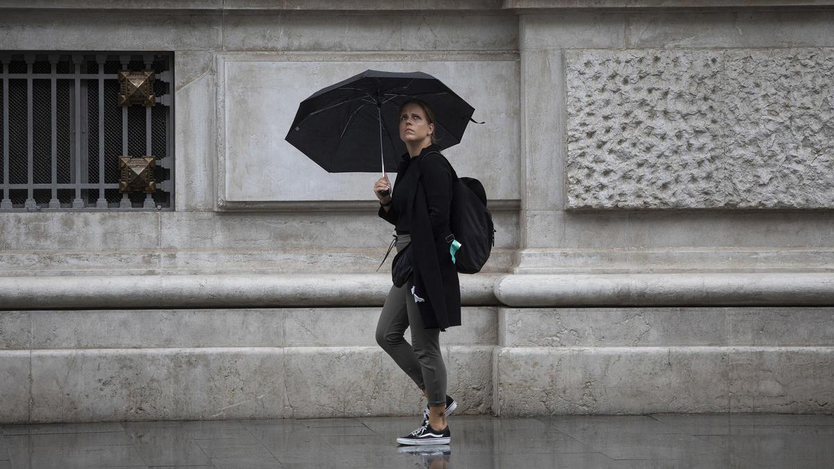 Una mujer se protege de la lluvia con su paraguas