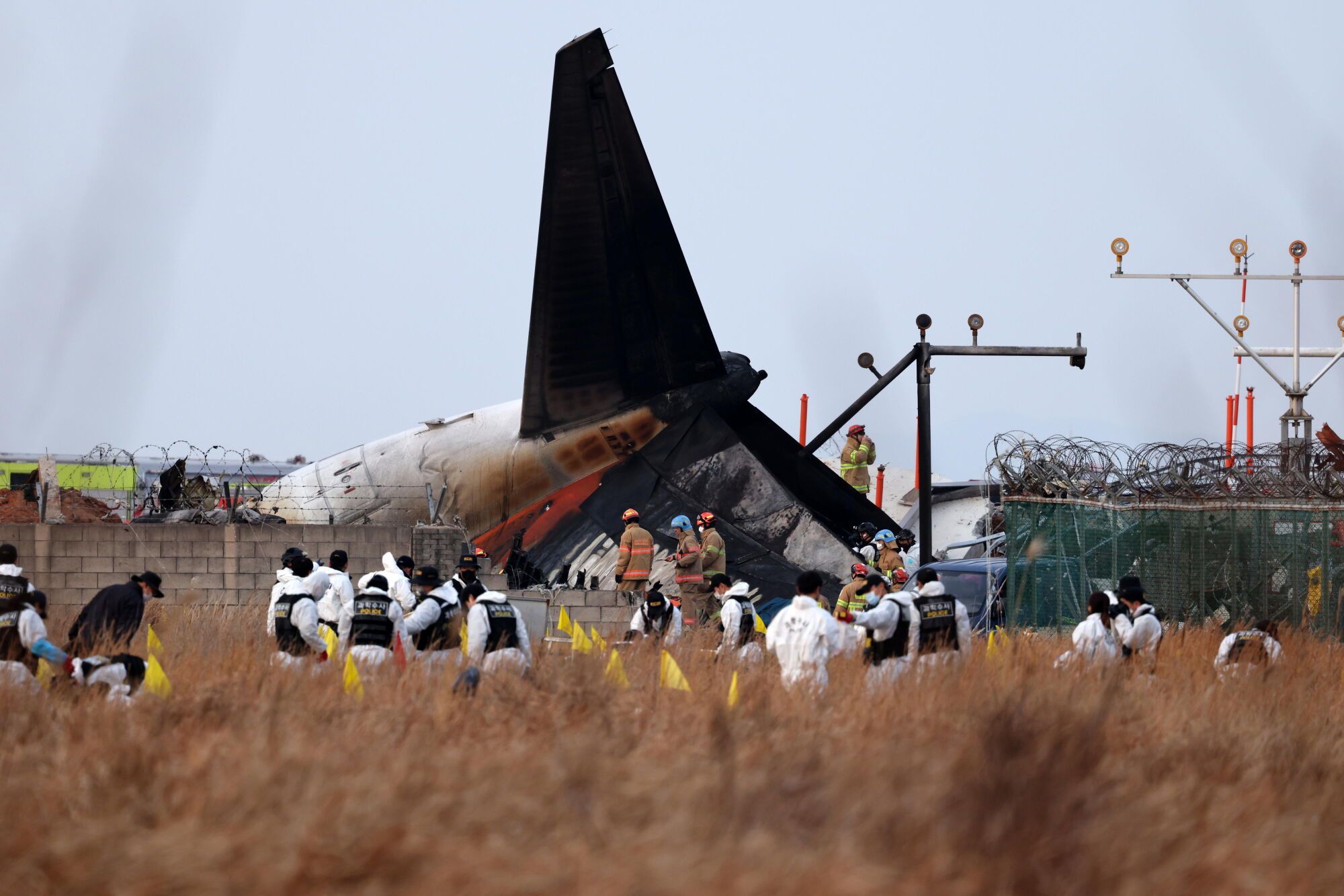 Muan (South Korea), 29/12/2024.- Members of Korea Crime Scene Investigation (KCSI) search around the wreckage of the Jeju Air aircraft at Muan International Airport in Muan, 288 kilometers southwest of Seoul, South Korea, 29 December 2024. According to the National Fire Agency, a passenger jet carrying 181 people erupted in flames after going off the runway at an airport in South Korea&#039;s southwestern county of Muan on 29 December, leaving at least 62 people dead. (Corea del Sur, Seúl) EFE/EPA/HAN MYUNG-GU
