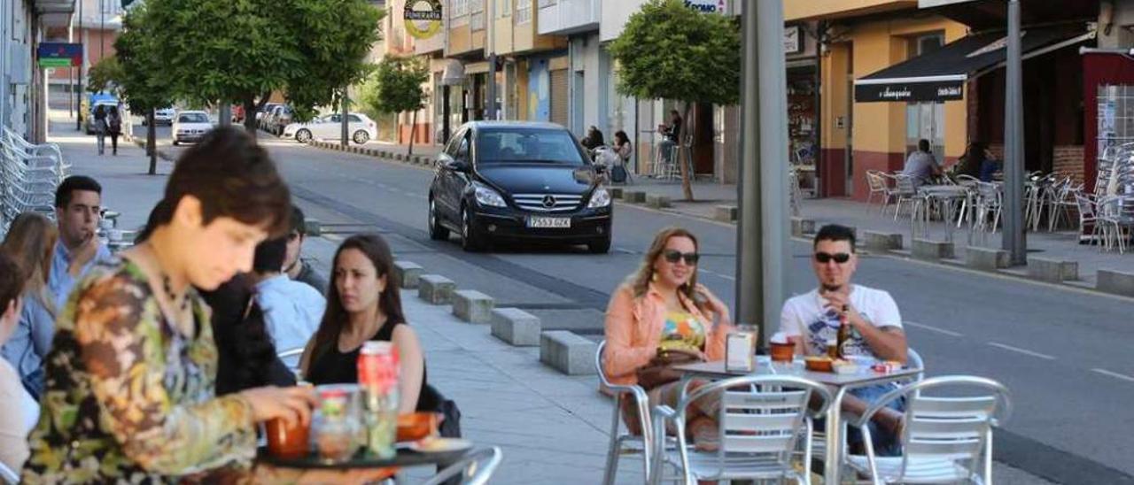 Una mujer atiende una terraza en la calle Rosalía de Castro, de Lalín. // Bernabé/Gutier