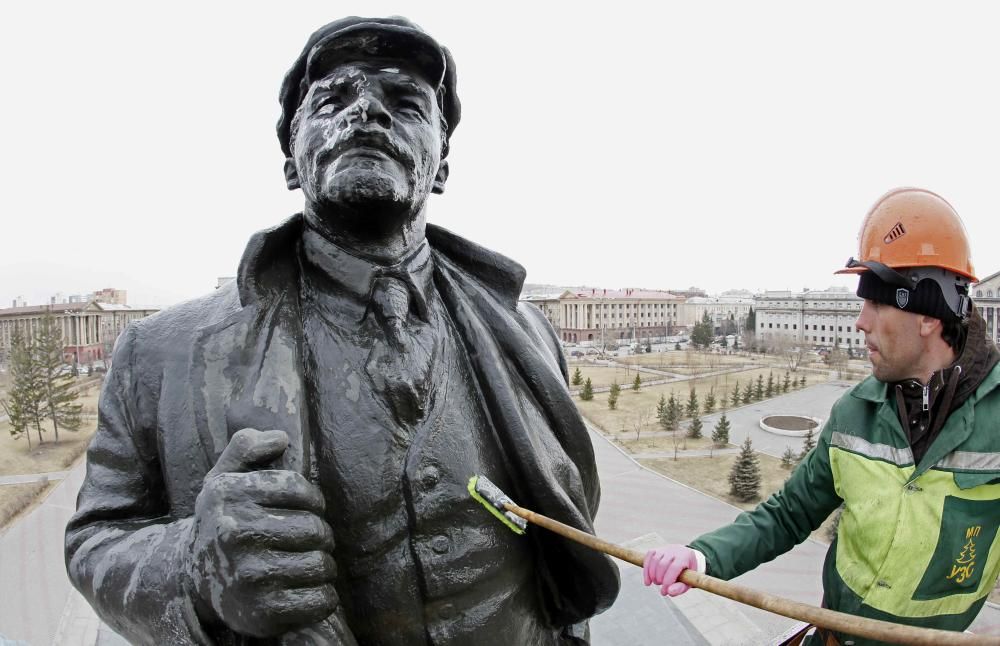 A worker washes a statue of the Soviet state ...