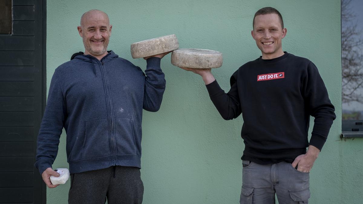 Jorge Rincón y Alberto Sotelo, uno de los trabajadores, con dos quesos de rueda de Touza Vella.