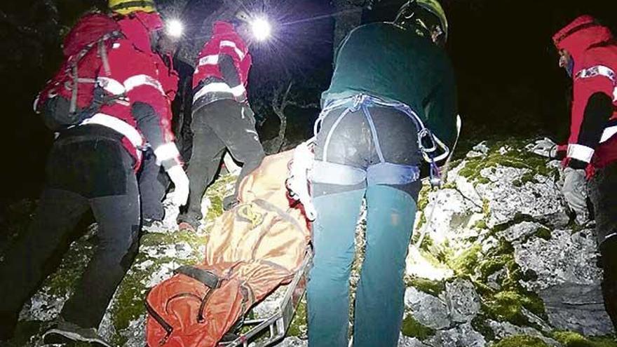 Guardias civiles y bomberos trasladan el cadáver del ermitaño.