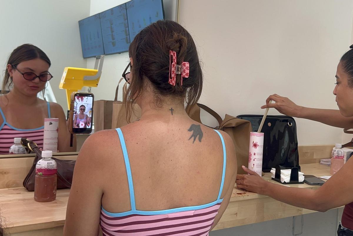Una turista graba un video para TikTok mientras muestra un tubo de 'sushi', en Sushi Bom (Málaga).