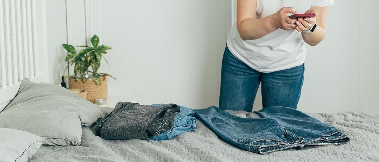 Una mujer fotografía prendas de ropa para venderlas por internet