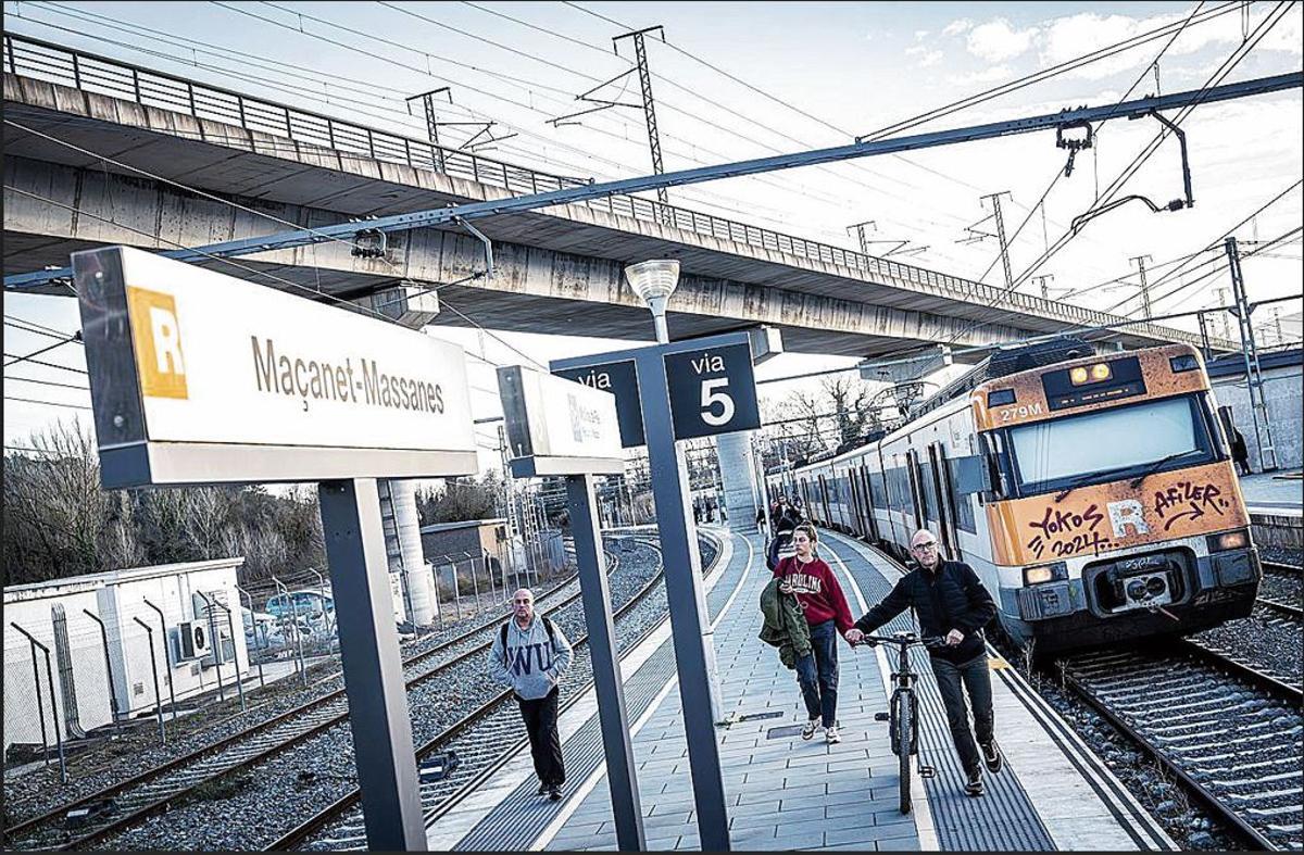 Un tren i diversos passatgers a l'estació de Massanet-Massanes