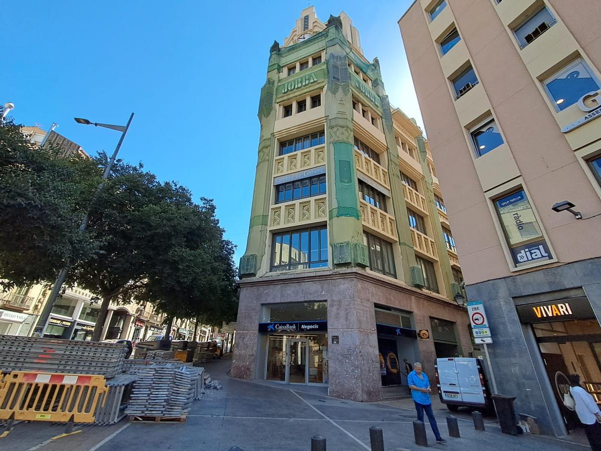 Vista frontal de l'edifici de can Jorba, amb el material per pujar les bastides a l'esquerra de la imatge, aquest dimarts