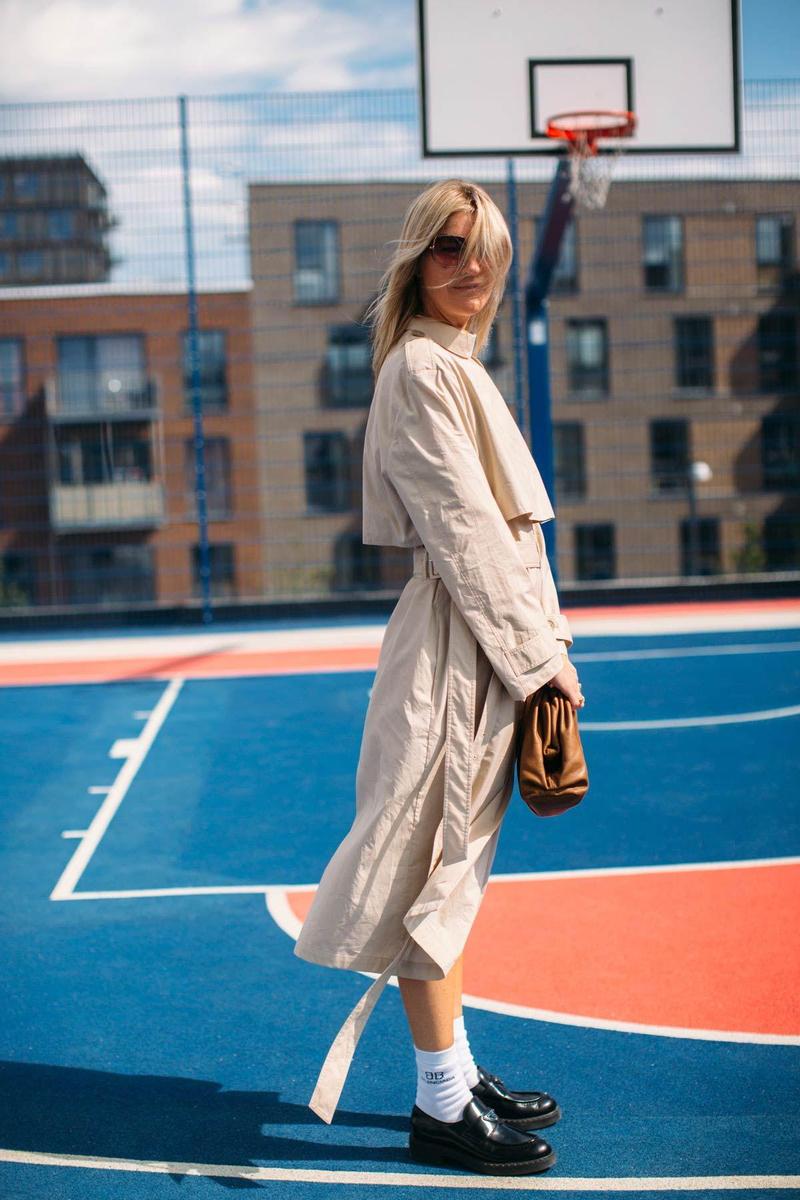 Look de gabardina combinada con mocasines con calcetines, visto en el street style de Copenhague