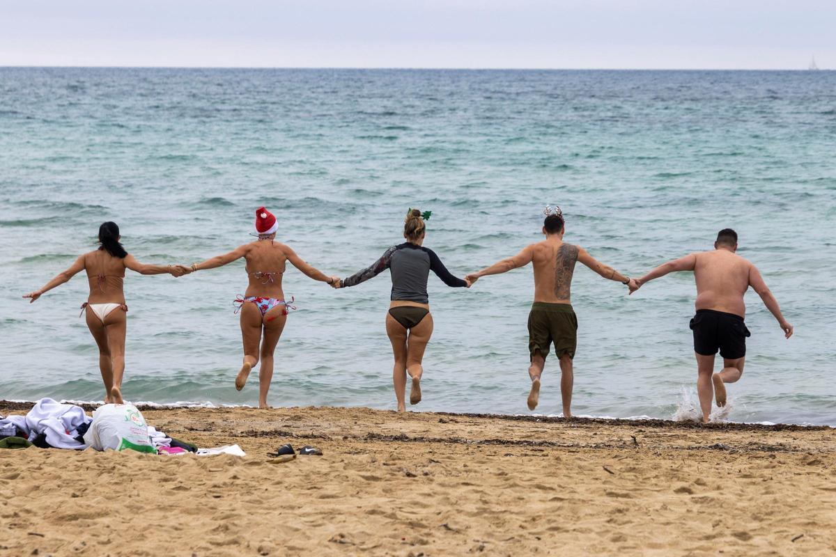 Un grupo de personas toma su primer baño del año durante las celebraciones de Año Nuevo en la playa de Ciudad Jardín en Palma de Mallorca, este sábado.