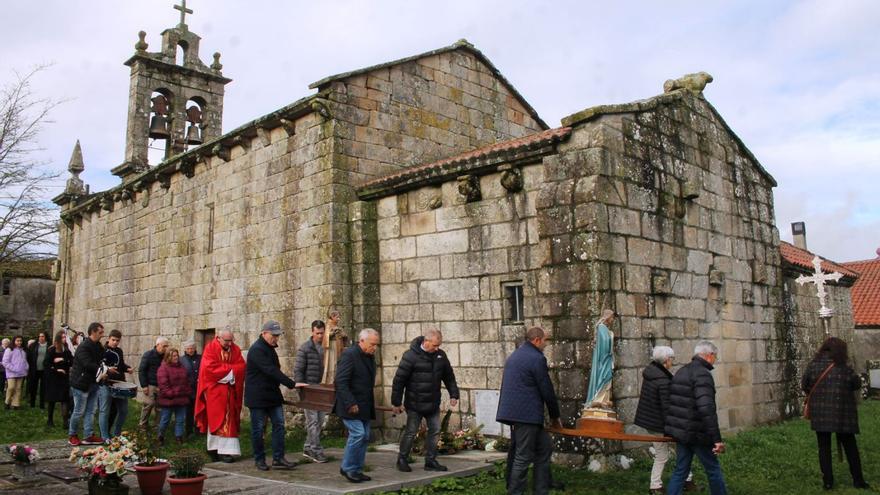 Procesión arredor da igrexa románica de Carboentes. Unha devota pasa o pano ao manto do Santo Estevo.   | // FOTOS: D.G.A.