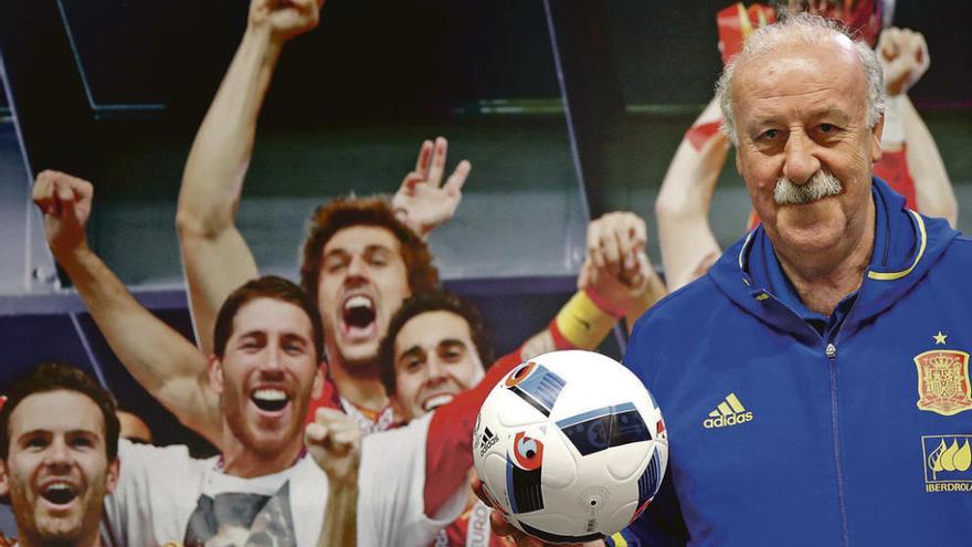 Vicente del Bosque posa delante de un póster con los jugadores españoles tras ganar la Eurocopa de 2012.