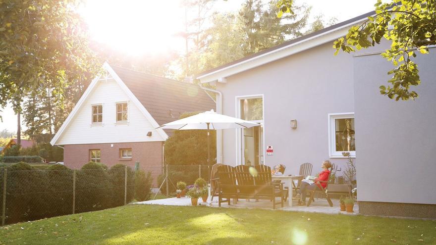 Dos mujeres observan el atardecer en el jardin de una casa.