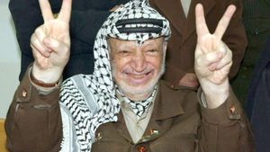 Yasir Arafat hace el signo de la victoria durante un encuentro en Ramala con líderes cristianos.