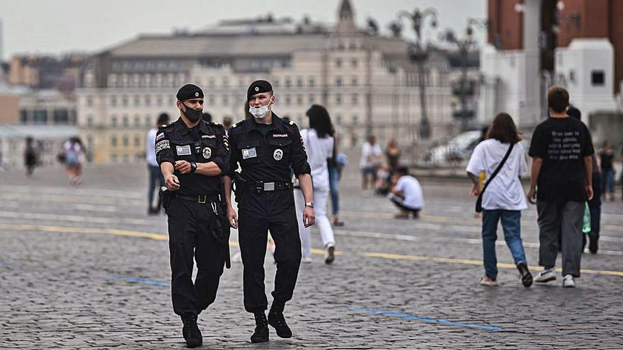 Policies amb mascareta patrullen per la plaça Roja de Moscou.