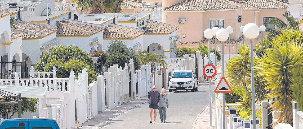 Dos personas caminan en una urbanización de San Fulgencio, municipio con una notable colonia extranjera.