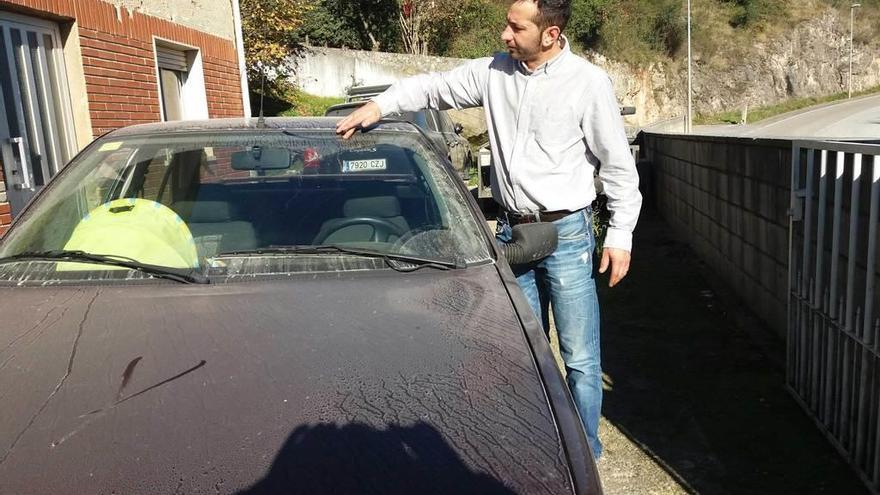 Juan Carlos González muestra el polvo acumulado sobre su coche en su casa de Llagú.