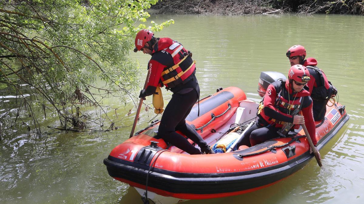 Los bomberos profesionales del parque de Palencia participan en el dispositivo de búsqueda de un hombre de 93 años con movilidad reducida que lleva un día desaparecido, en la imagen inspeccionan la orilla del río Carrión a su paso por la capital